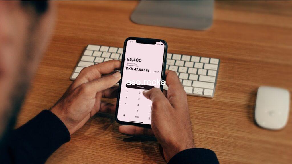 Person using a banking transfer app on a smartphone at a desk, representing practical remittance tips for UK-based Nigerians